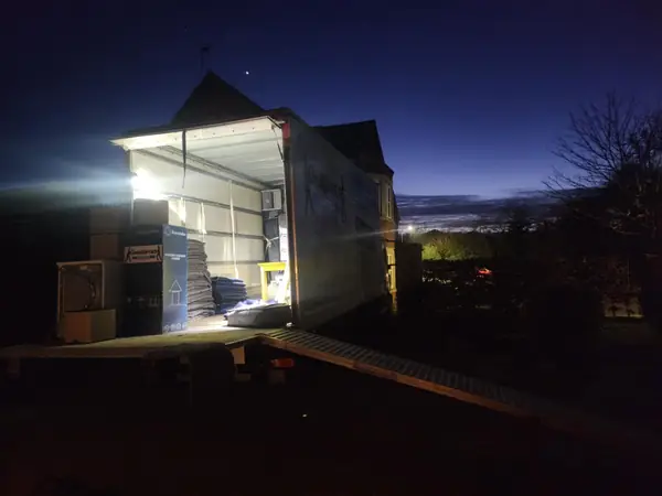 Gentlevan removals lorry loading at first light outside a house, tail lift down and boxes ready