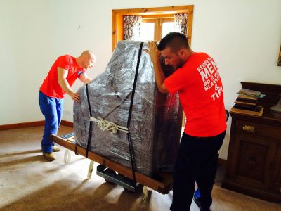 Moving a fully wrapped baby-grand piano on a dolly and piano shoe