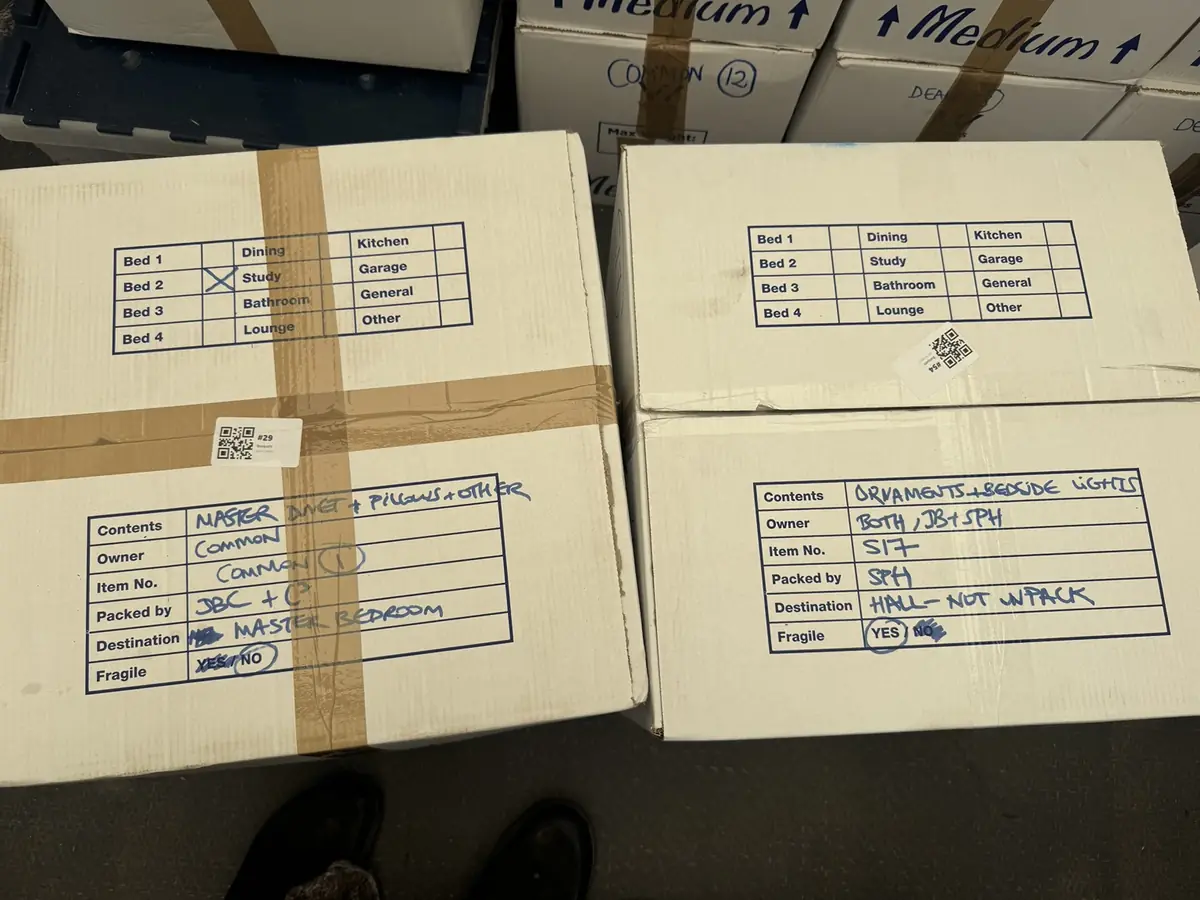Two taped Gentlevan cartons with numbered QR code labels and hand written contents, owner, item number, destination room and fragile fields