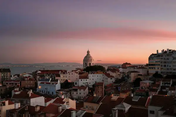 Alfama rooftops and the National Pantheon dome above the Tagus at sunset, Lisbon, Portugal - UK to Lisbon removals by Gentlevan