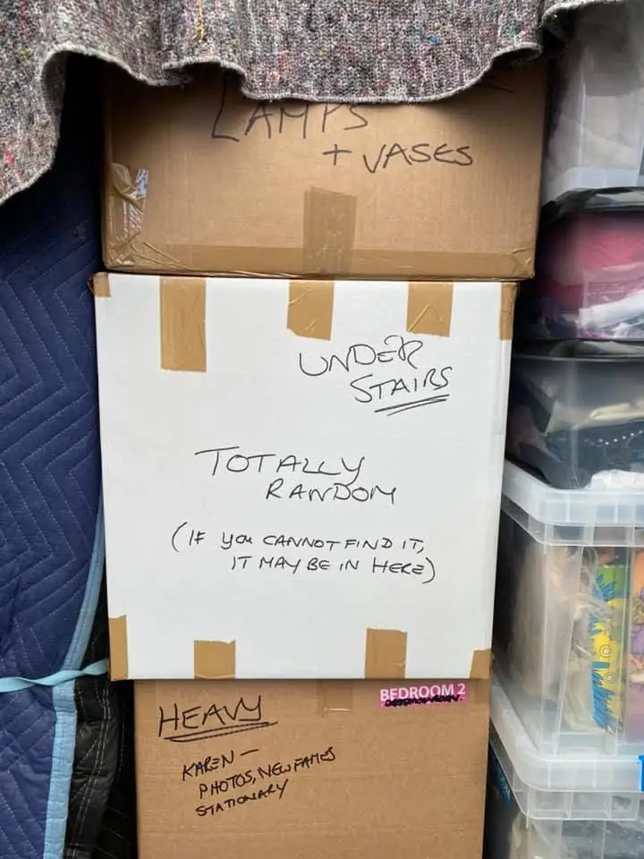 Cartons hand labelled by room, reading lamps and vases, under stairs and heavy, loaded against removal blankets