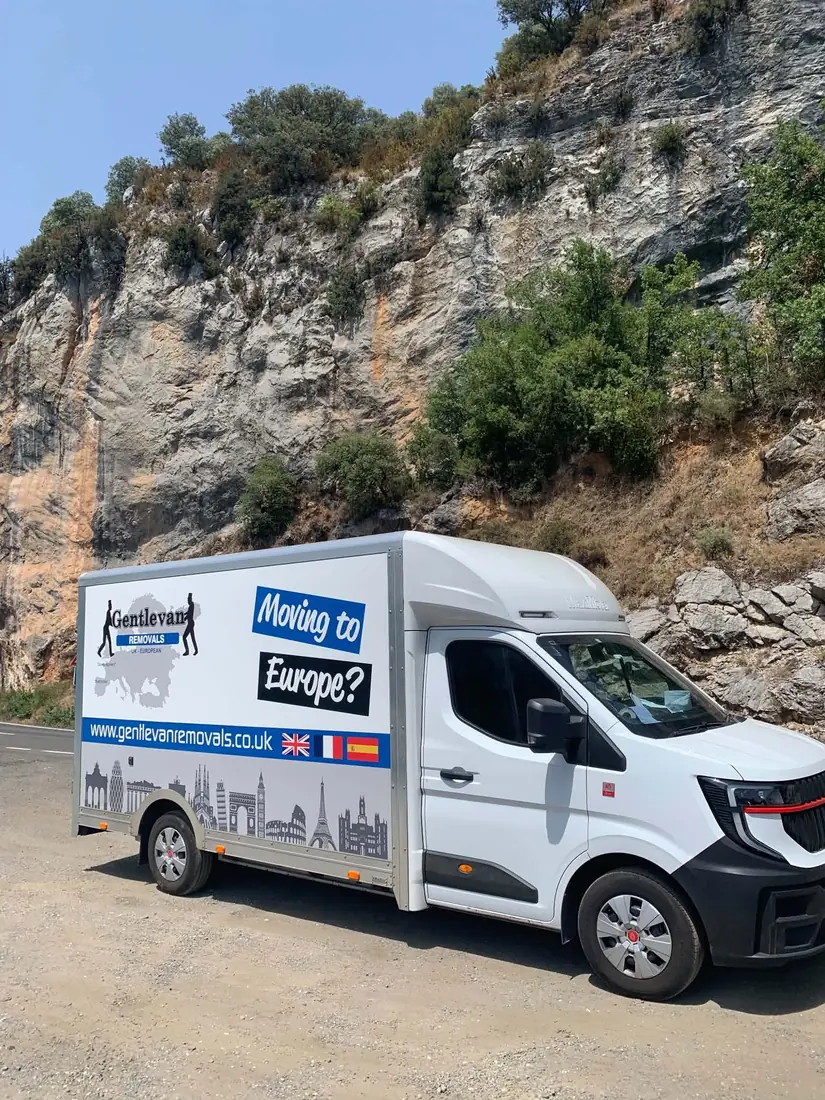 Gentlevan Removals Moving to Europe transhipment van parked below a limestone crag on a southern European route