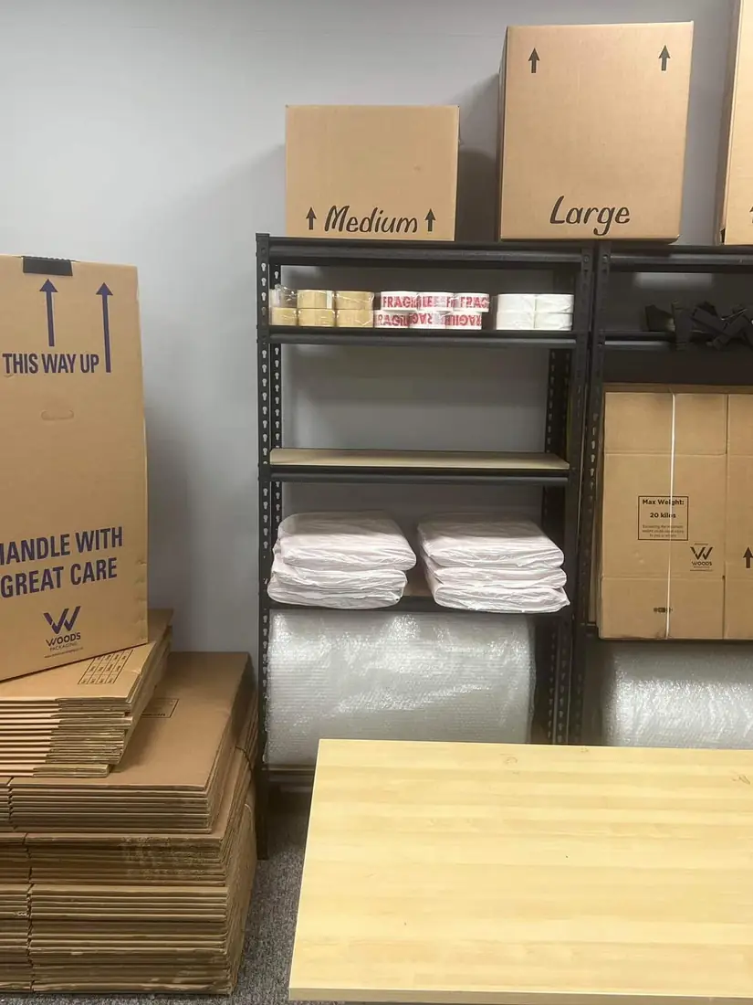 Removal cartons in medium, large and tall sizes on shelving beside bubble wrap, mattress covers and flat packed boxes at the Gentlevan Removals store